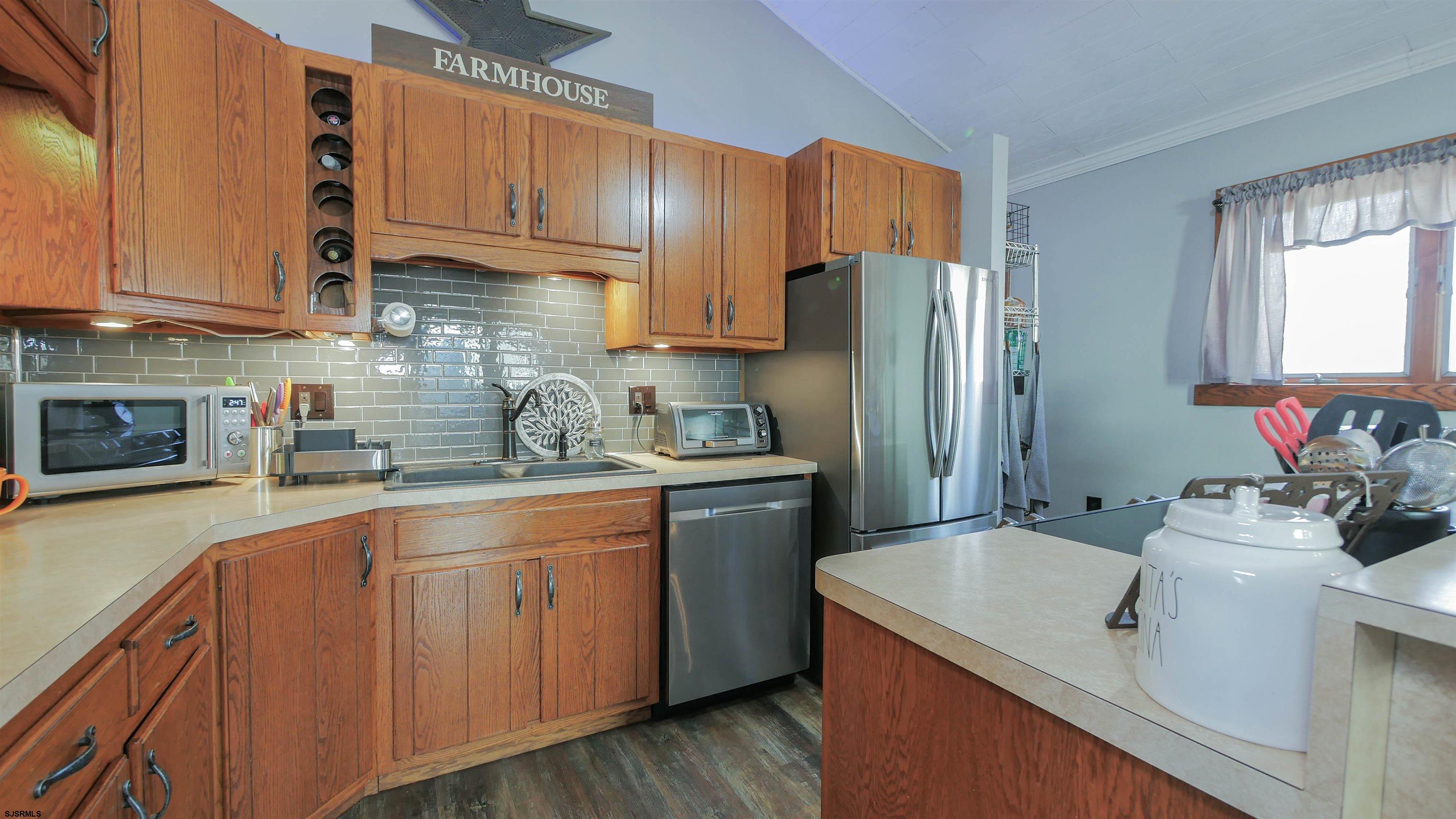 337 Broad Street Milmay, NJ 08330 - Photo 20 of 36 a kitchen with stainless steel appliances granite countertop a sink stove refrigerator and cabinets