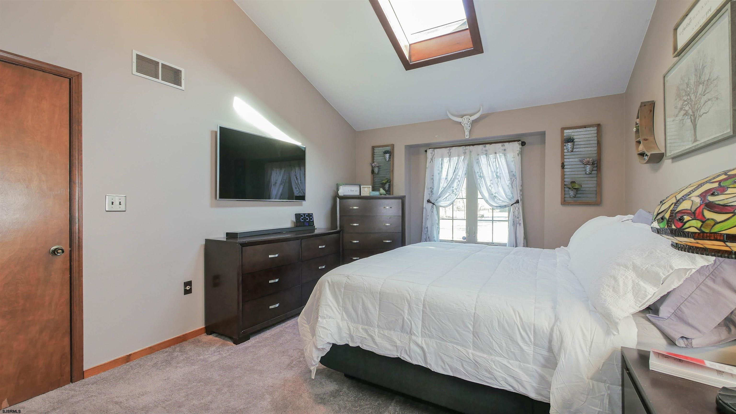 337 Broad Street Milmay, NJ 08330 - Photo 25 of 36 a bedroom with a bed and a flat tv screen on dresser