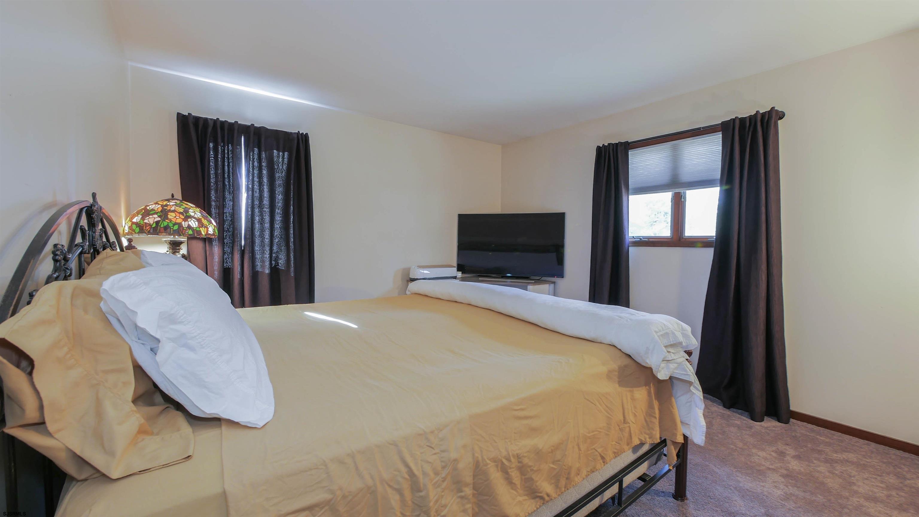 337 Broad Street Milmay, NJ 08330 - Photo 30 of 36 a bedroom with a bed and flat screen tv