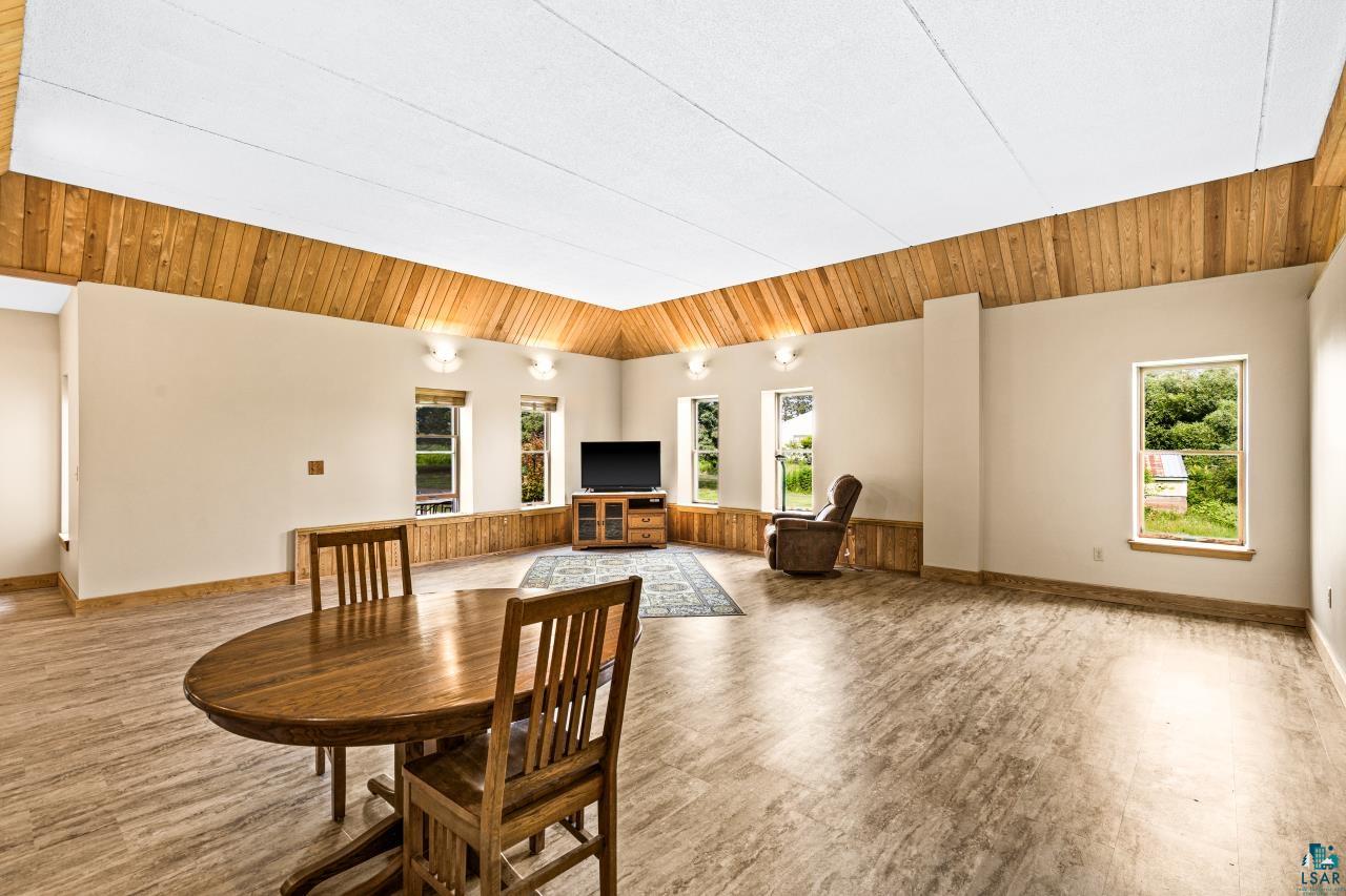 4800 Tower Road Moose Lake, MN 55767 - Photo 14 of 83 Spacious room featuring wood-finish flooring, light-toned walls, and a vaulted ceiling with wood paneling