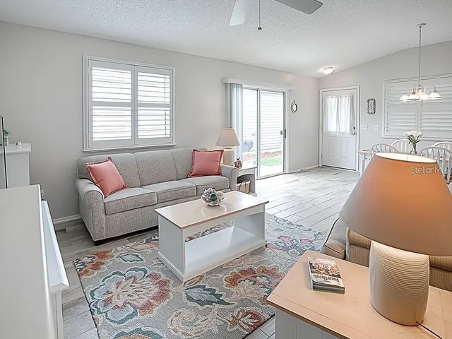 a dining room with furniture a chandelier and wooden floor