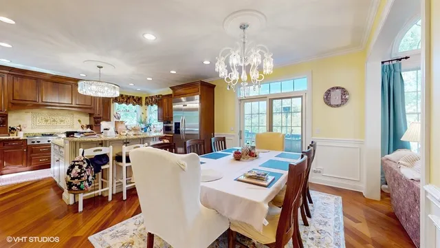 a view of a dining room with furniture a chandelier and wooden floor