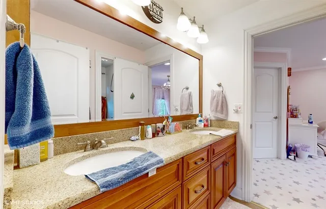 a bedroom with a bed window and a chandelier