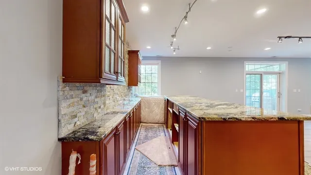 a view of a house with a big yard and potted plants and large trees