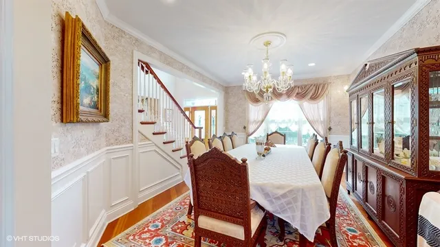 a view of a dining room with furniture a chandelier and wooden floor