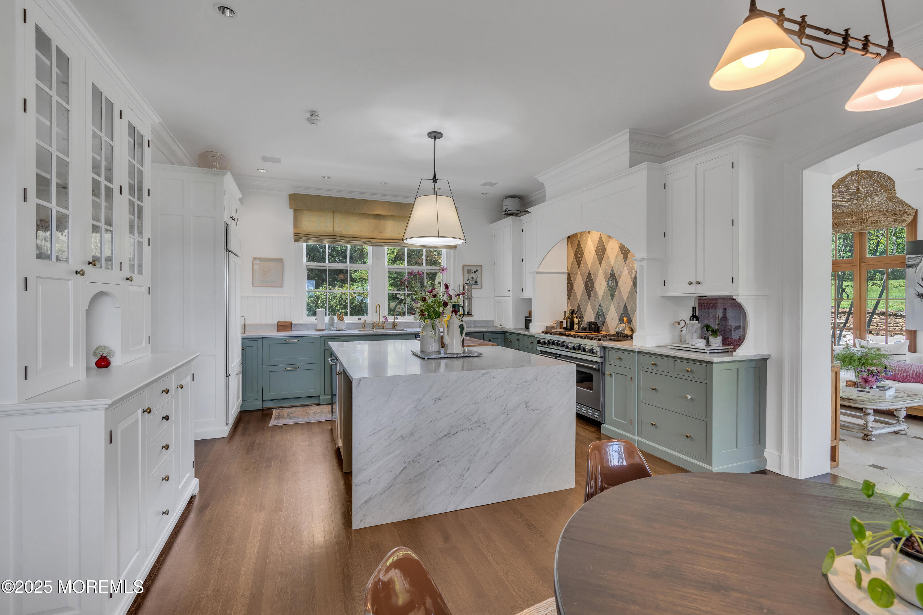 809 Navesink River Road Rumson, NJ 07760 - Photo 18 of 45 a large kitchen with kitchen island granite countertop a stove a sink a dining table and chairs with wooden floor