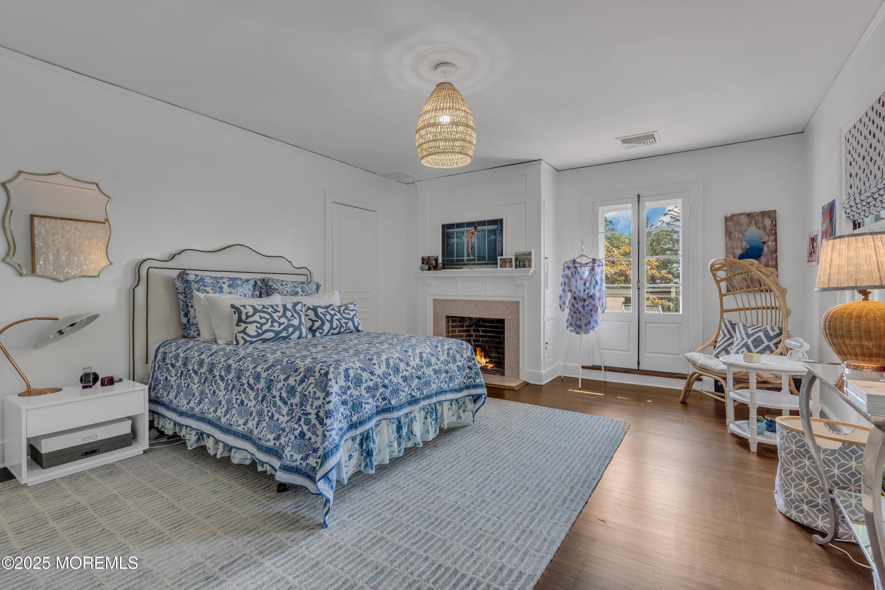 809 Navesink River Road Rumson, NJ 07760 - Photo 23 of 45 a bedroom with a bed a chandelier and a fireplace