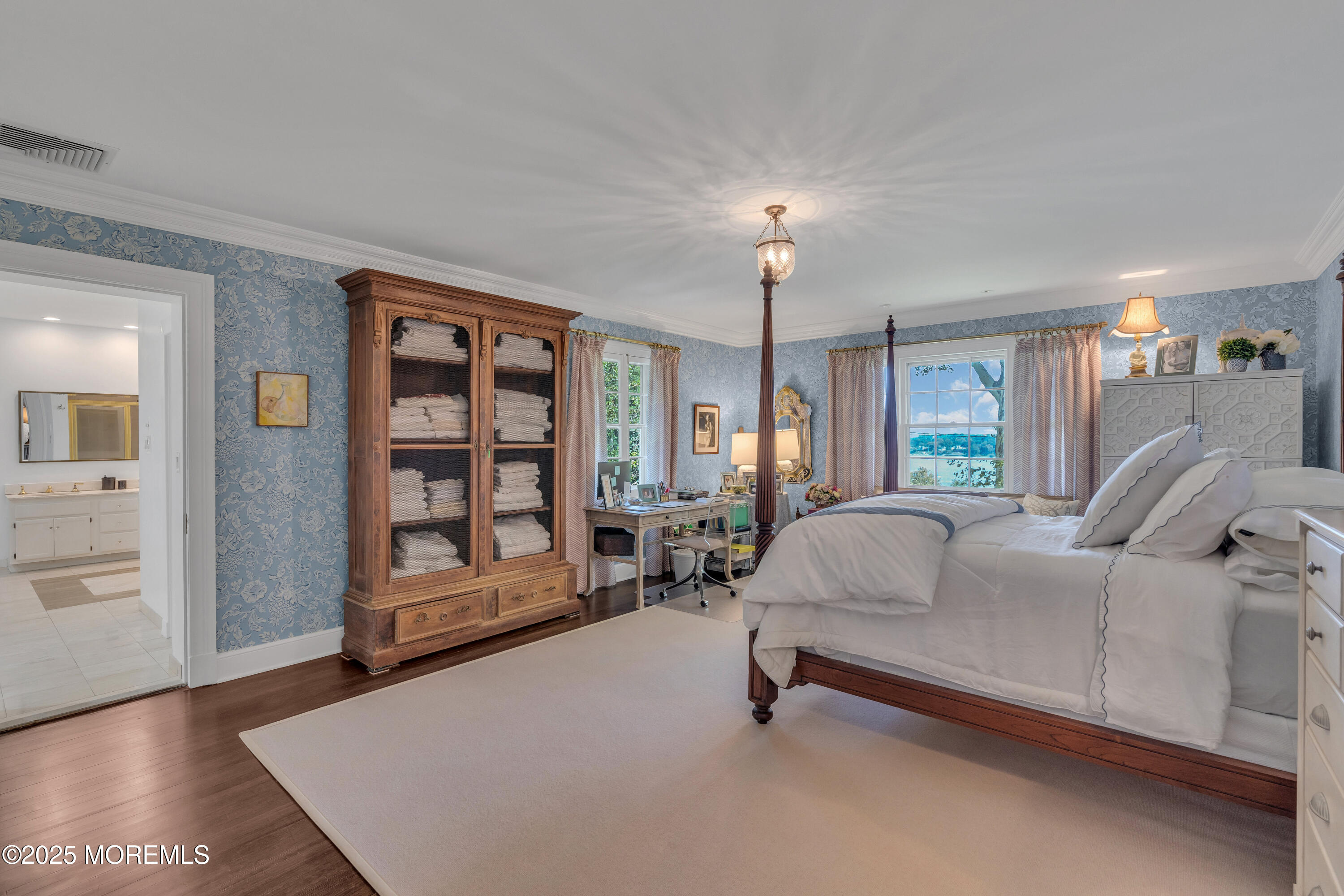809 Navesink River Road Rumson, NJ 07760 - Photo 28 of 45 a spacious bedroom with a bed a table and wooden floor