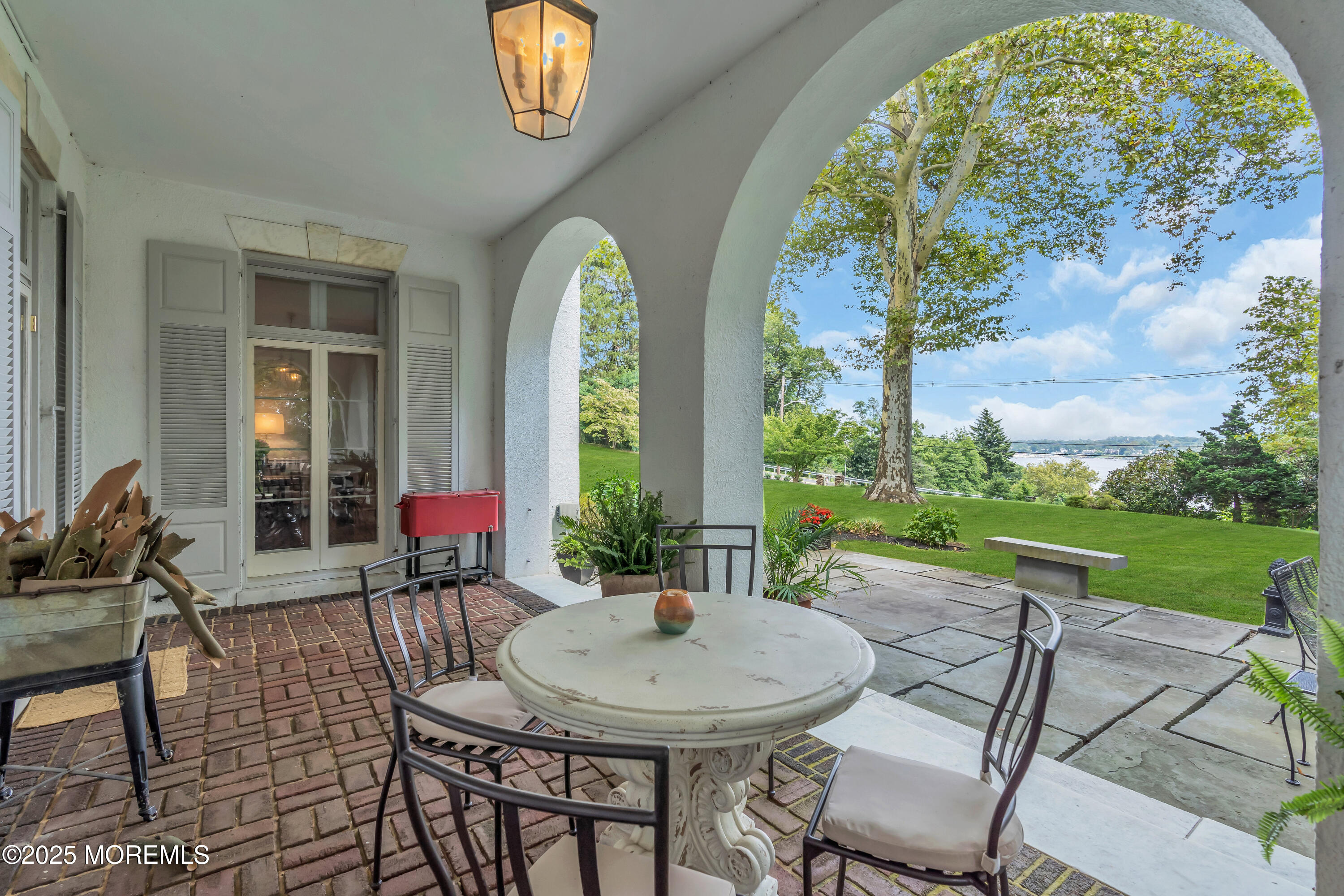 809 Navesink River Road Rumson, NJ 07760 - Photo 31 of 45 a view of a patio with table and chairs potted plants and a large tree