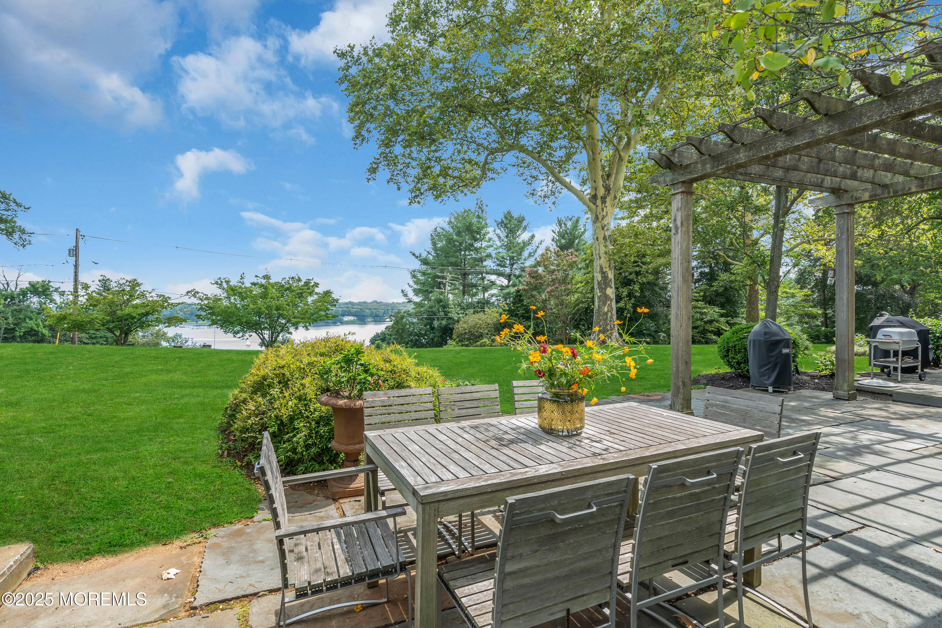 809 Navesink River Road Rumson, NJ 07760 - Photo 35 of 45 a view of a patio with table and chairs potted plants with large tree