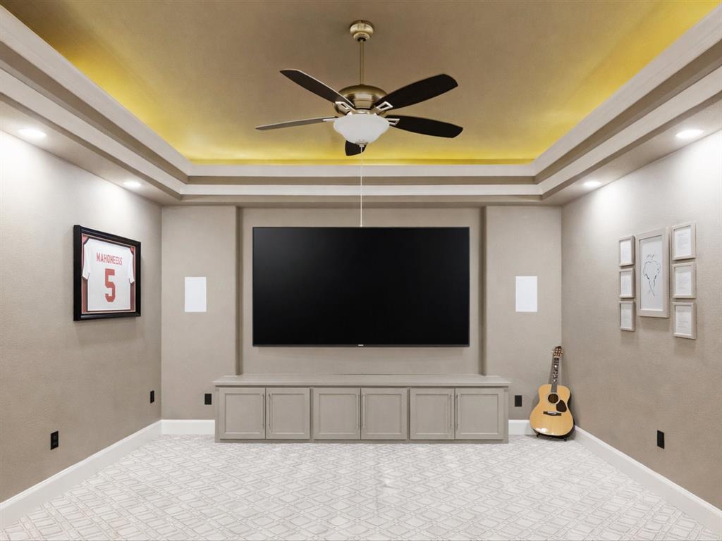 621 Hawk Wood Lane Prosper, TX 75078 - Photo 14 of 40 a living room with a flat screen tv and a ceiling fan