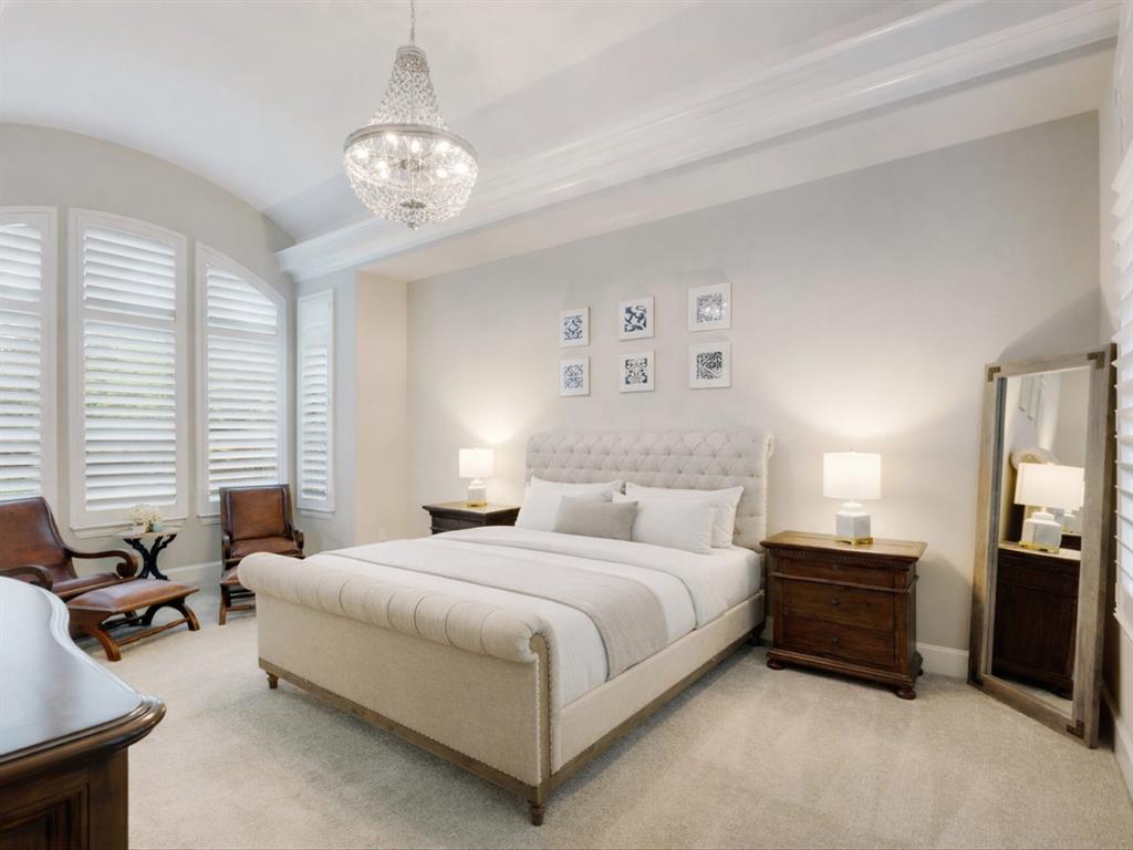 621 Hawk Wood Lane Prosper, TX 75078 - Photo 19 of 40 a spacious bedroom with a bed a chandelier and a couch
