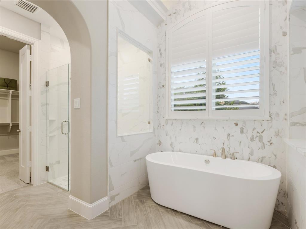 621 Hawk Wood Lane Prosper, TX 75078 - Photo 21 of 40 a white bath tub sitting in a bathroom with shower