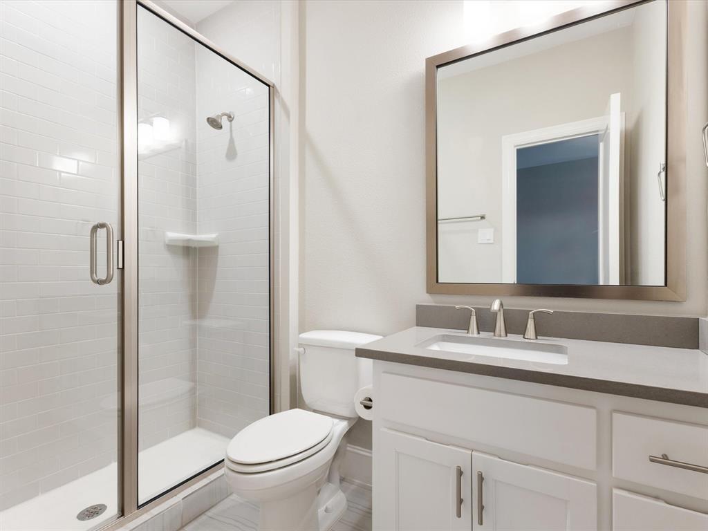 621 Hawk Wood Lane Prosper, TX 75078 - Photo 29 of 40 a bathroom with a granite countertop sink toilet and shower