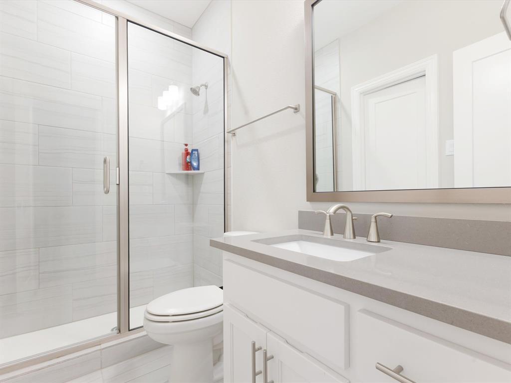 621 Hawk Wood Lane Prosper, TX 75078 - Photo 31 of 40 a bathroom with a granite countertop sink toilet and shower