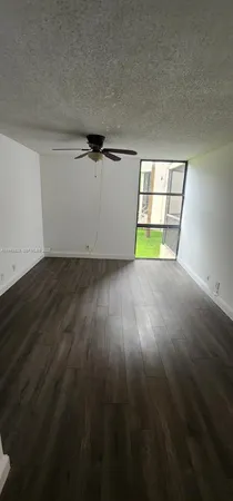 an empty room with wooden floor and natural light