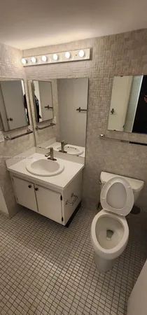 a bathroom with a sink mirror vanity and toilet