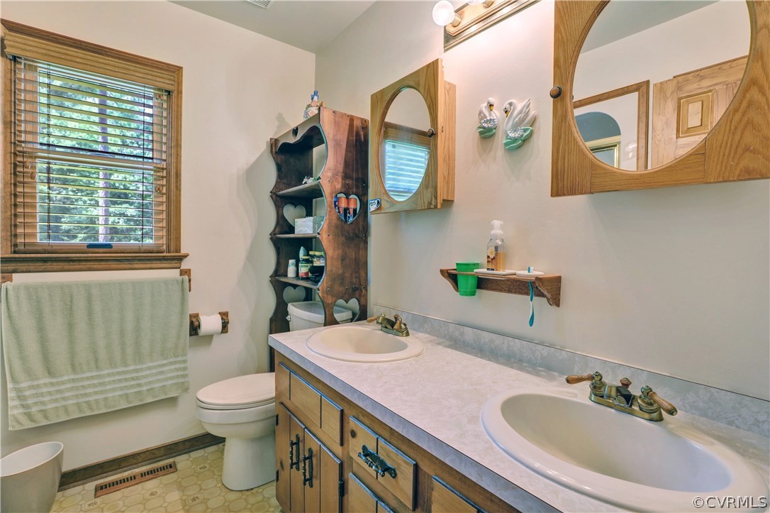 15100 Beach Road Chesterfield, VA 23838 - Photo 20 of 41 a bathroom with a sink a toilet and a mirror