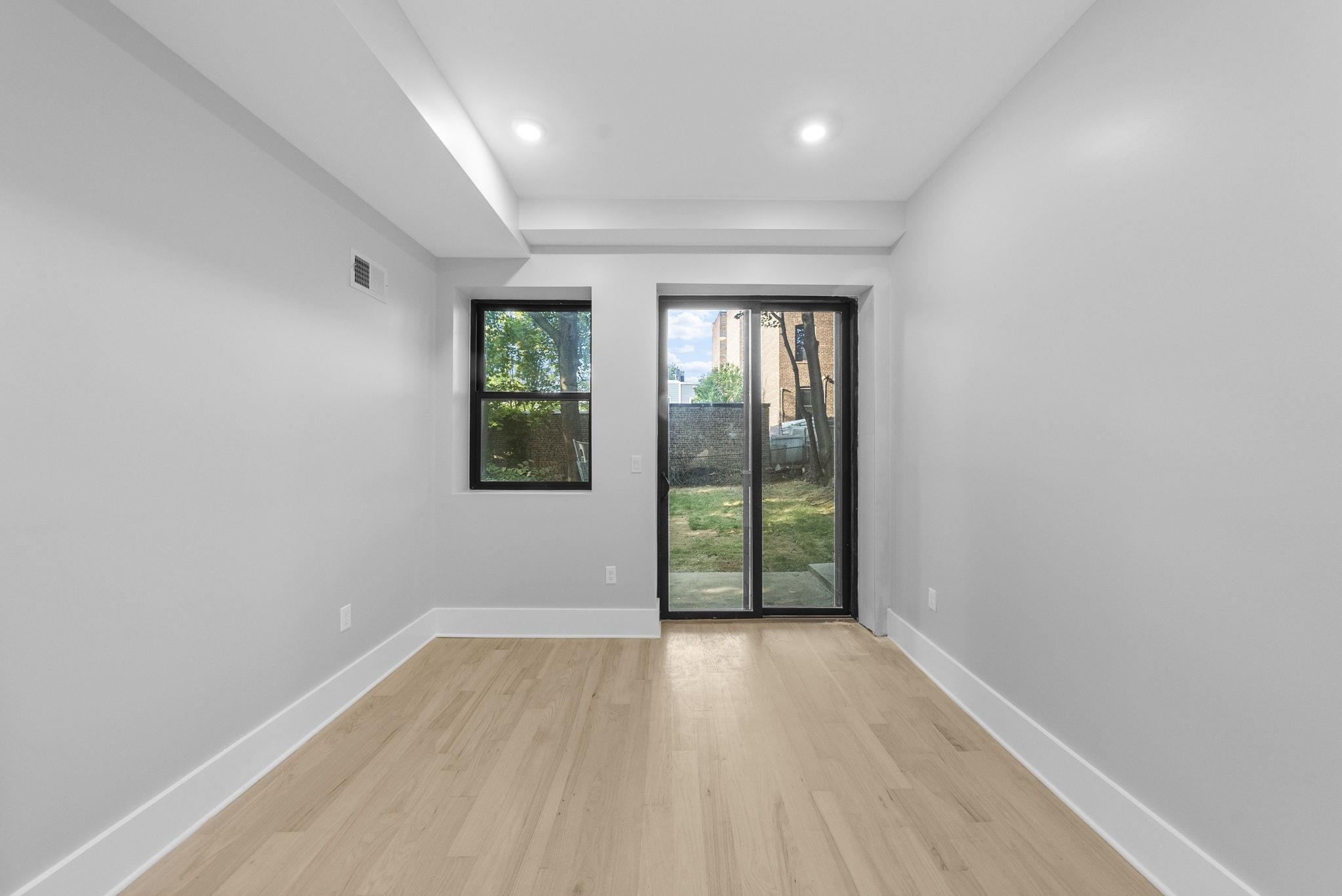 124 Glenwood Avenue Jersey City, NJ 07306 - Photo 21 of 42 wooden floor in an empty room with a window