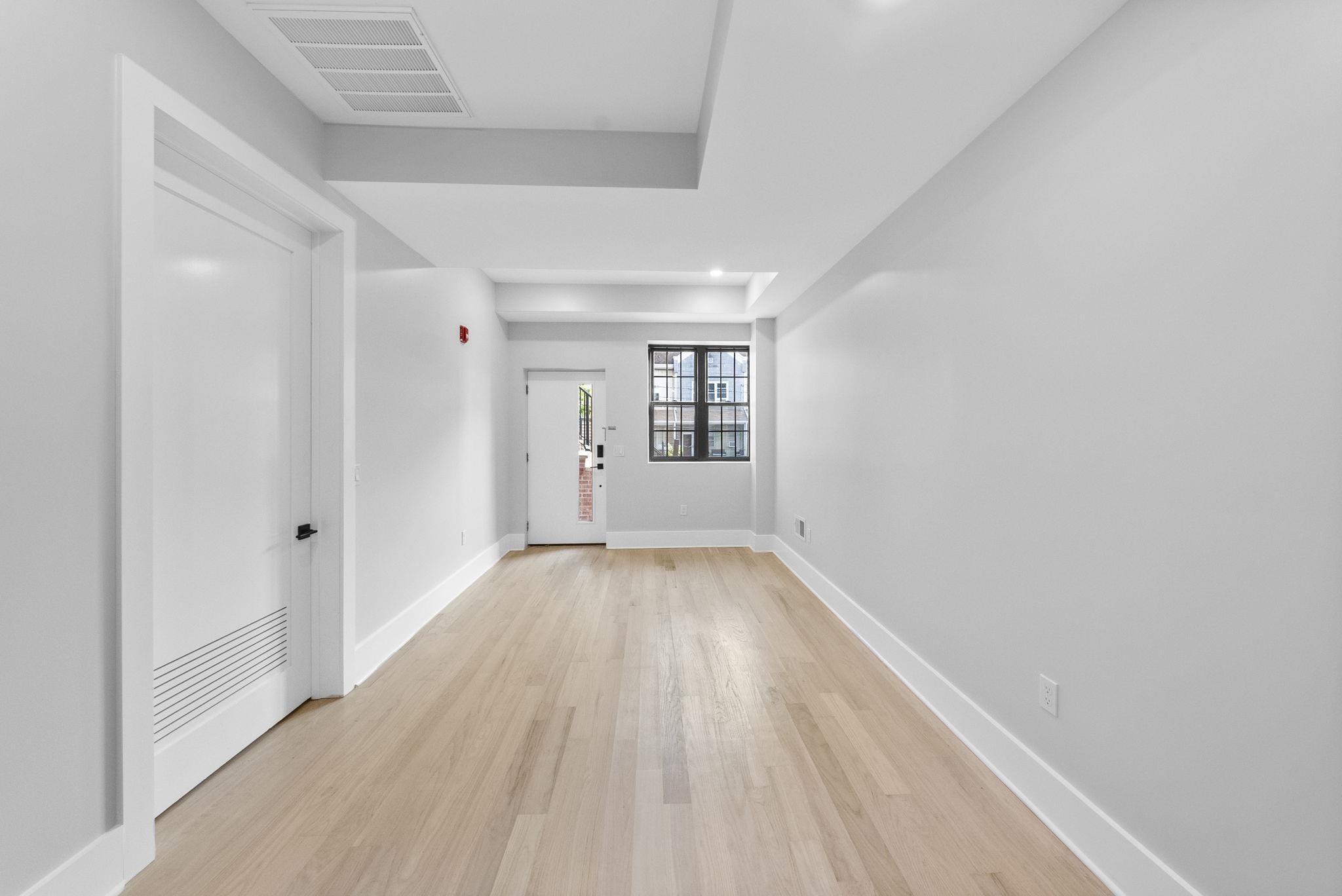 124 Glenwood Avenue Jersey City, NJ 07306 - Photo 26 of 42 wooden floor in an empty room with a window