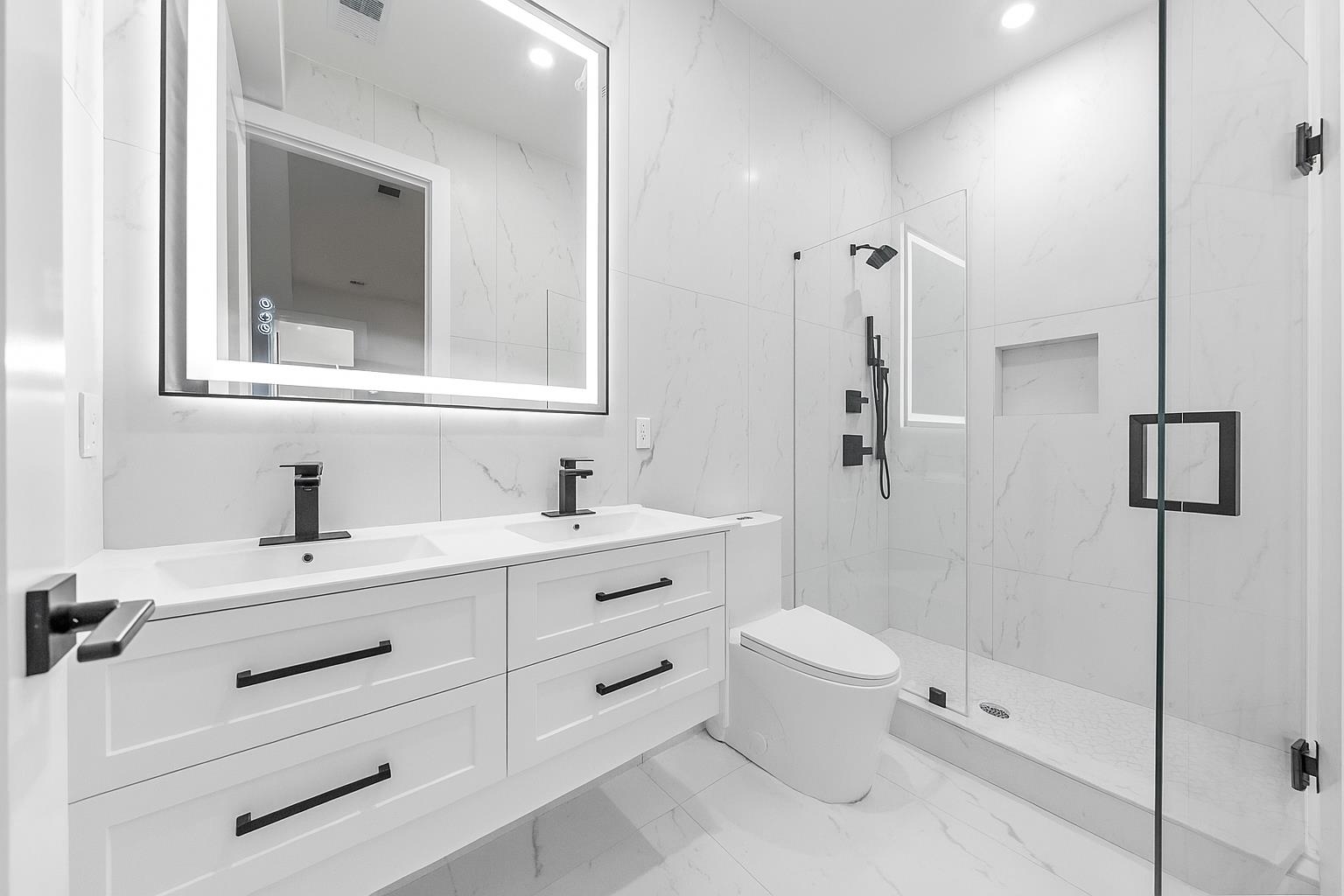 124 Glenwood Avenue Jersey City, NJ 07306 - Photo 29 of 42 a bathroom with a double vanity sink toilet mirror and shower