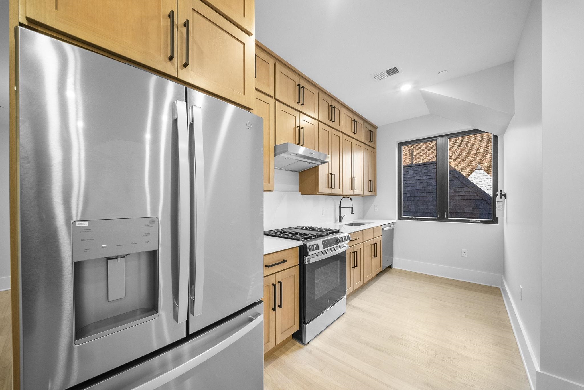 124 Glenwood Avenue Jersey City, NJ 07306 - Photo 7 of 42 a kitchen with stainless steel appliances granite countertop a refrigerator a stove and a sink