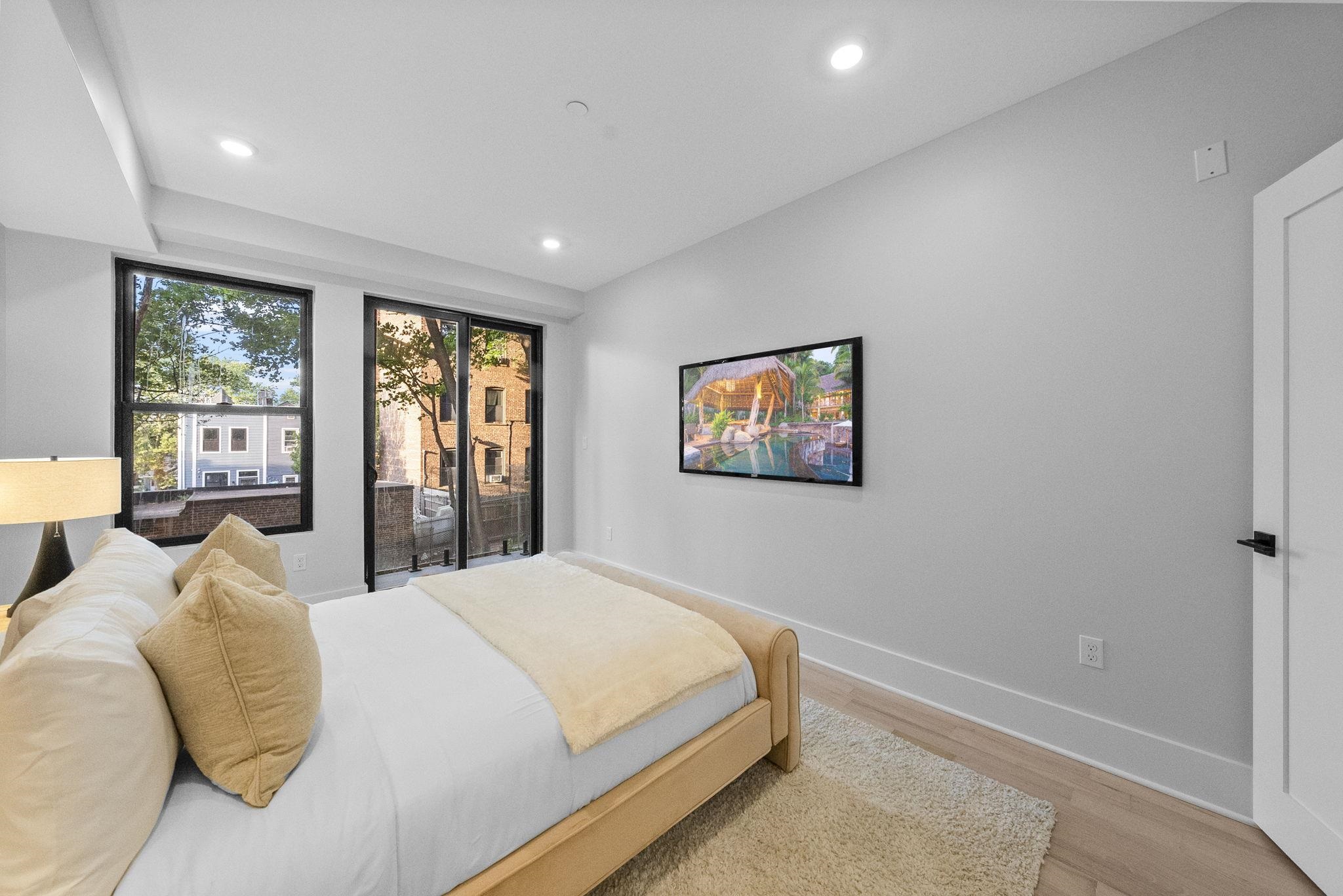124 Glenwood Avenue Jersey City, NJ 07306 - Photo 10 of 42 a bedroom with a large bed and a window