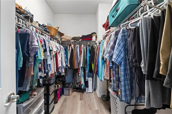 a view of walk in closet with clothes