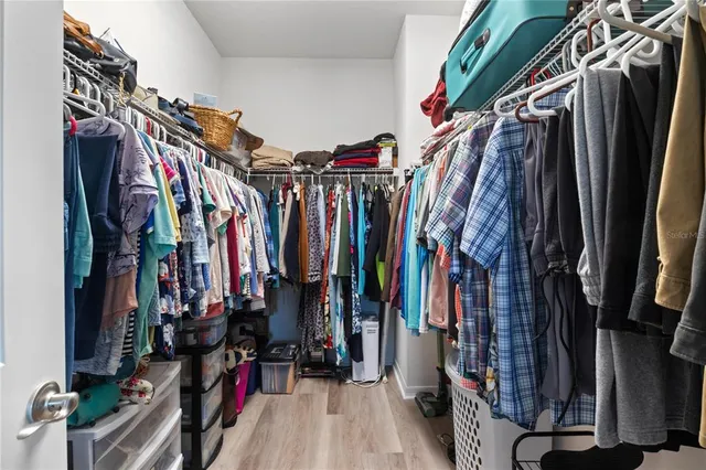 a view of walk in closet with clothes