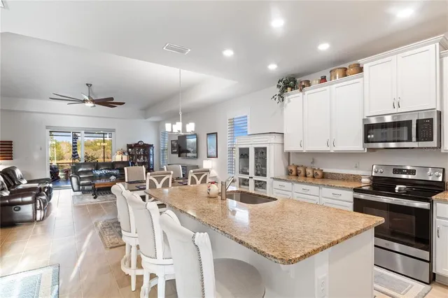 a kitchen with counter space appliances and a view of living room