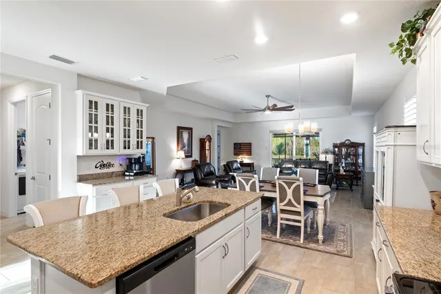 a kitchen with stainless steel appliances granite countertop a table and chairs