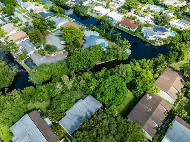 an aerial view of a house with a yard and large trees