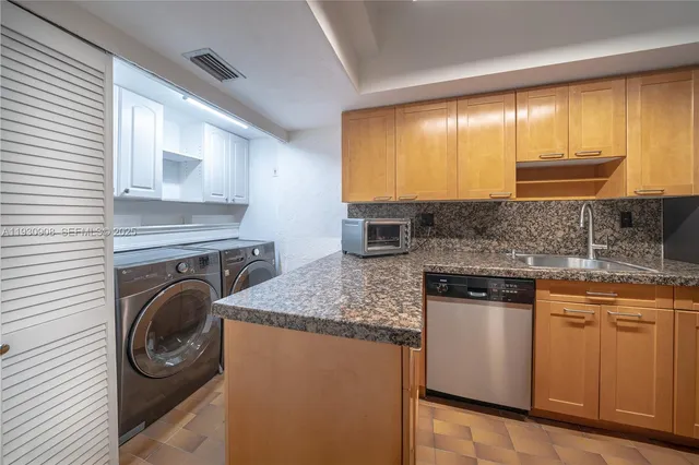 a kitchen with a sink cabinets and a washer dryer