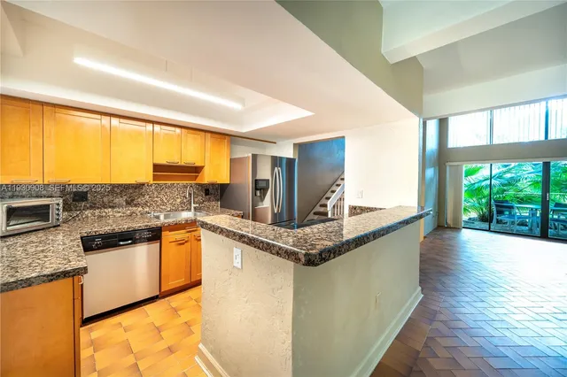 a kitchen with stainless steel appliances granite countertop a sink and a counter space