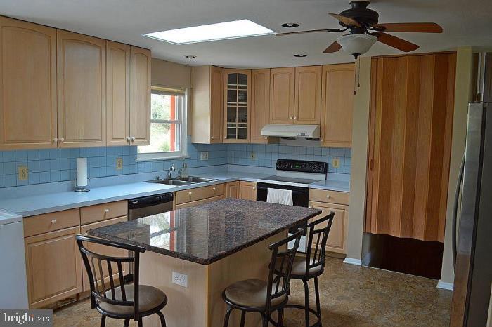 5953 Kedron Street Springfield, VA 22150 - Photo 2 of 28 a kitchen with stainless steel appliances a table and chairs in it