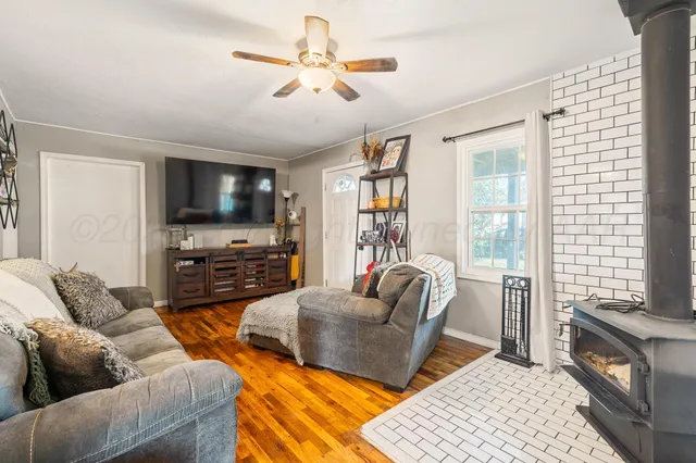 a living room with furniture a flat screen tv and a large window