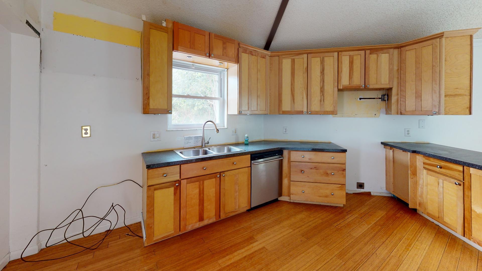 29188 Tulip Lane Big Pine Key, FL 33043 - Photo 15 of 26 a kitchen with granite countertop wooden floors a sink and appliances