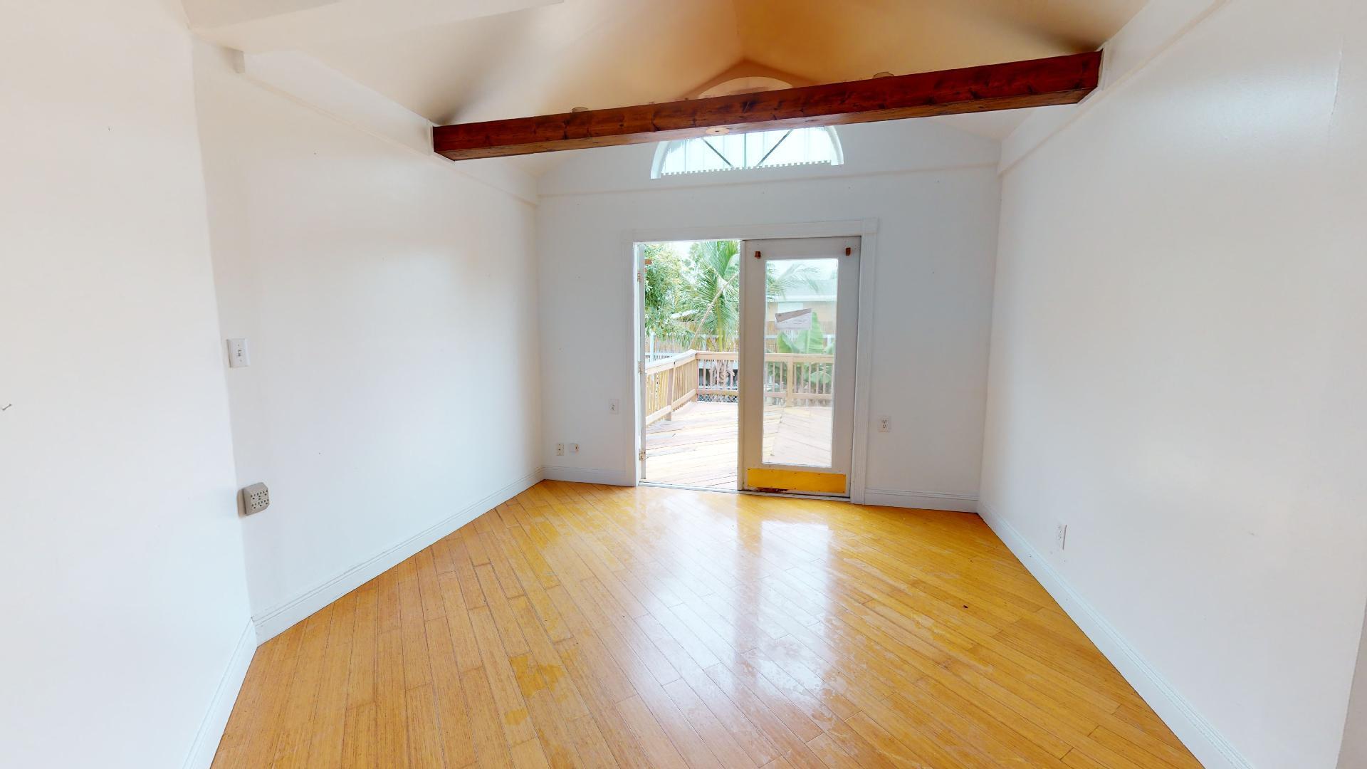 29188 Tulip Lane Big Pine Key, FL 33043 - Photo 16 of 26 a view of an empty room with wooden floor and a window
