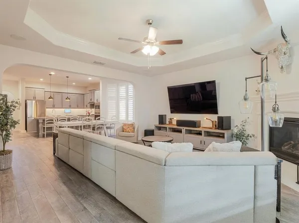 a living room with stainless steel appliances kitchen island furniture and a flat screen tv