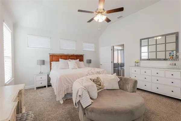 a bedroom with a bed chandelier and a window