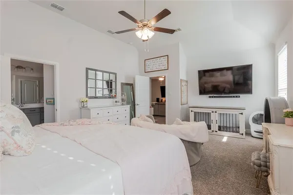 a bedroom with a bed a window and a flat screen television