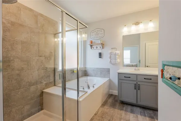 a bathroom with a tub a sink shower and mirror