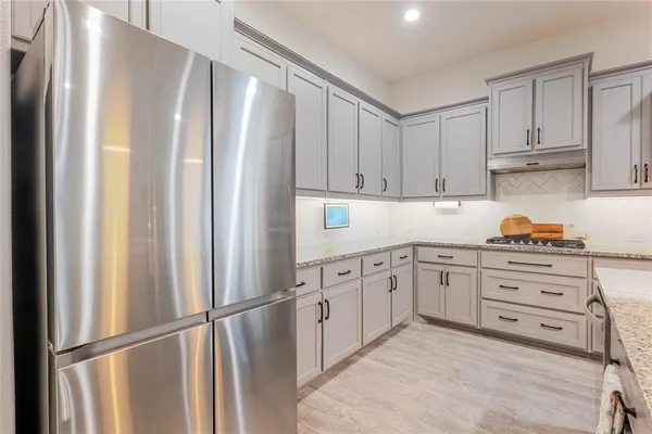 a kitchen with stainless steel appliances granite countertop a refrigerator sink and cabinets