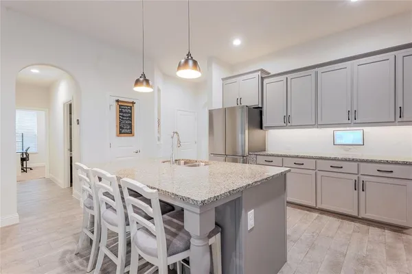 a kitchen with a island a sink cabinets and refrigerator