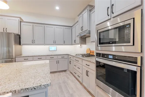 a kitchen with granite countertop cabinets stainless steel appliances and a counter space