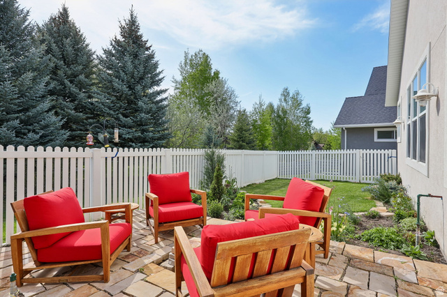 1238 Canyon View Road Midway, UT 84049 - Photo 29 of 36 Stone-paved patio with a white picket fence, surrounded by mature evergreen trees