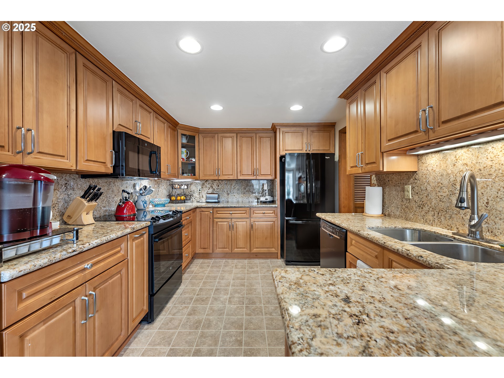 15435 Southwest 114th Court, Unit 99 Tigard, OR 97224 - Photo 12 of 40 a kitchen with granite countertop wooden cabinets a refrigerator stove top oven and sink