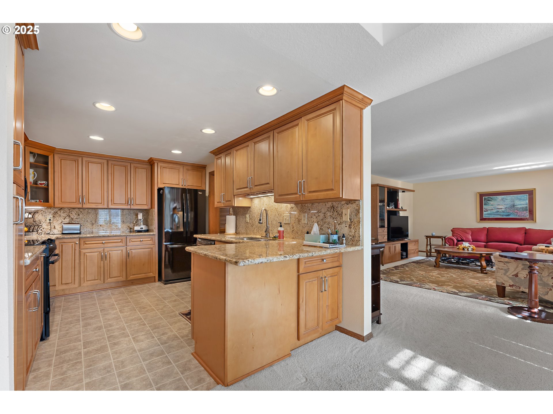 15435 Southwest 114th Court, Unit 99 Tigard, OR 97224 - Photo 15 of 40 a kitchen with stainless steel appliances kitchen island granite countertop a refrigerator and a stove top oven