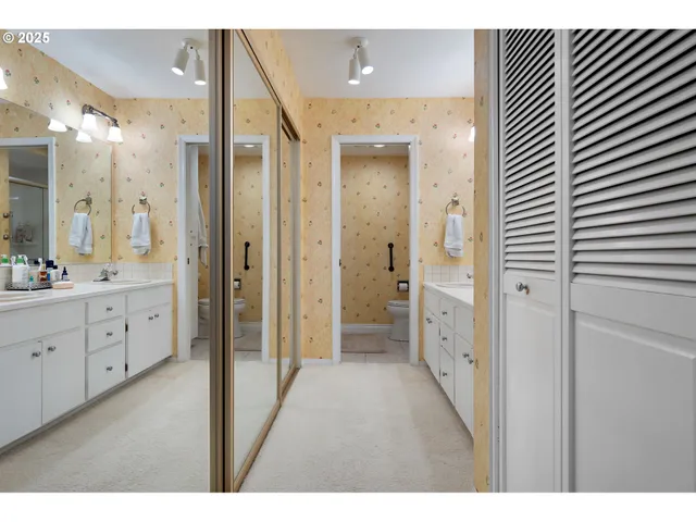 a bathroom with a double vanity sink a toilet and a shower