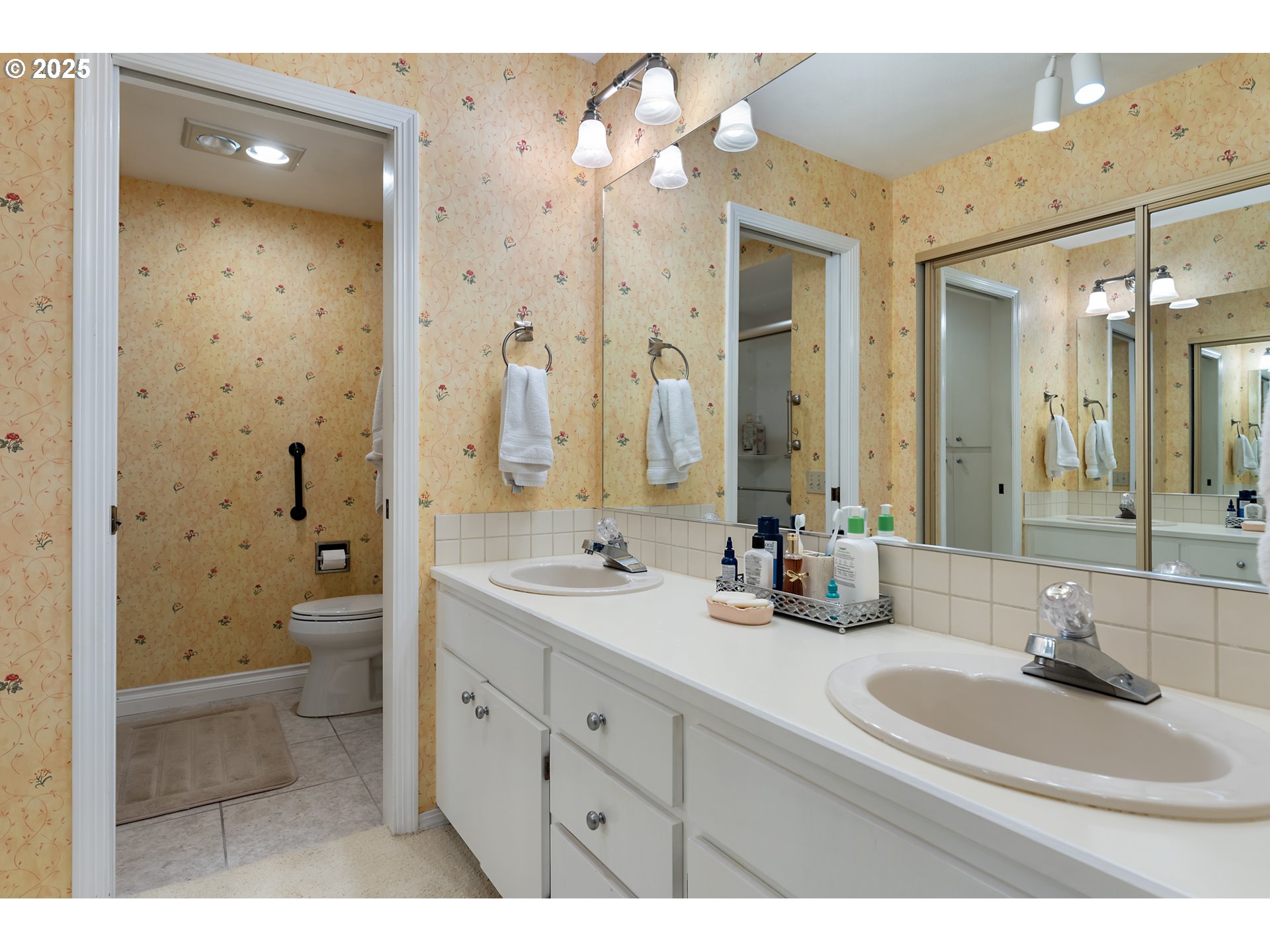 15435 Southwest 114th Court, Unit 99 Tigard, OR 97224 - Photo 22 of 40 a bathroom with a double vanity sink mirror double shower and a toilet